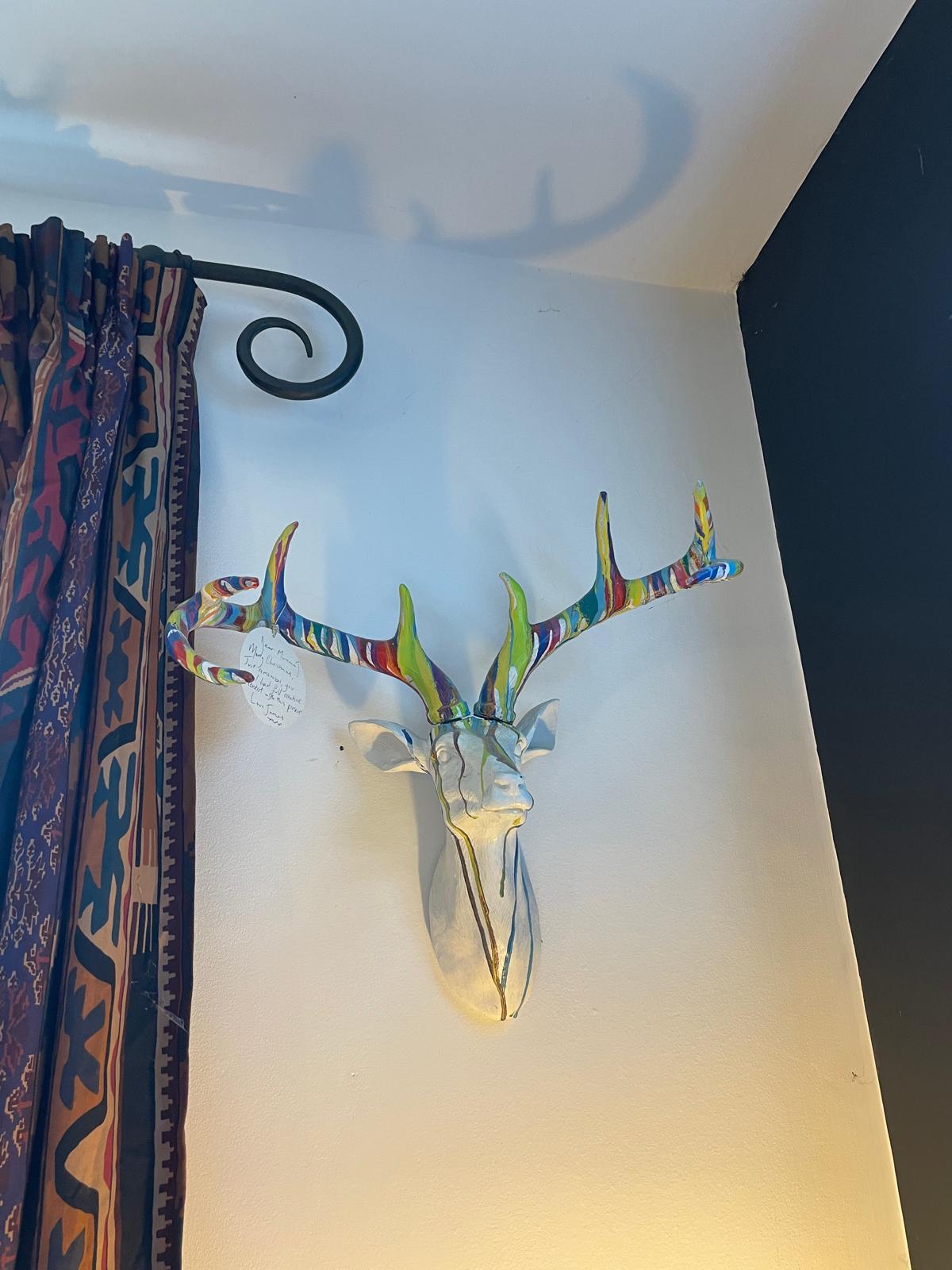 Colorful deer head wall art with vibrant antlers, adding a unique touch to a luxury cottage interior