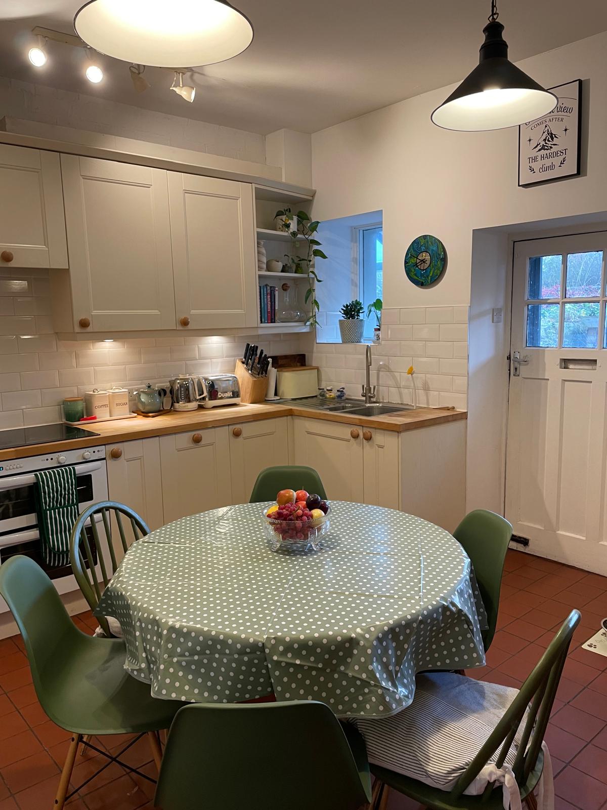 Cozy luxury cottage kitchen featuring a round dining table, modern appliances, and bright natural light