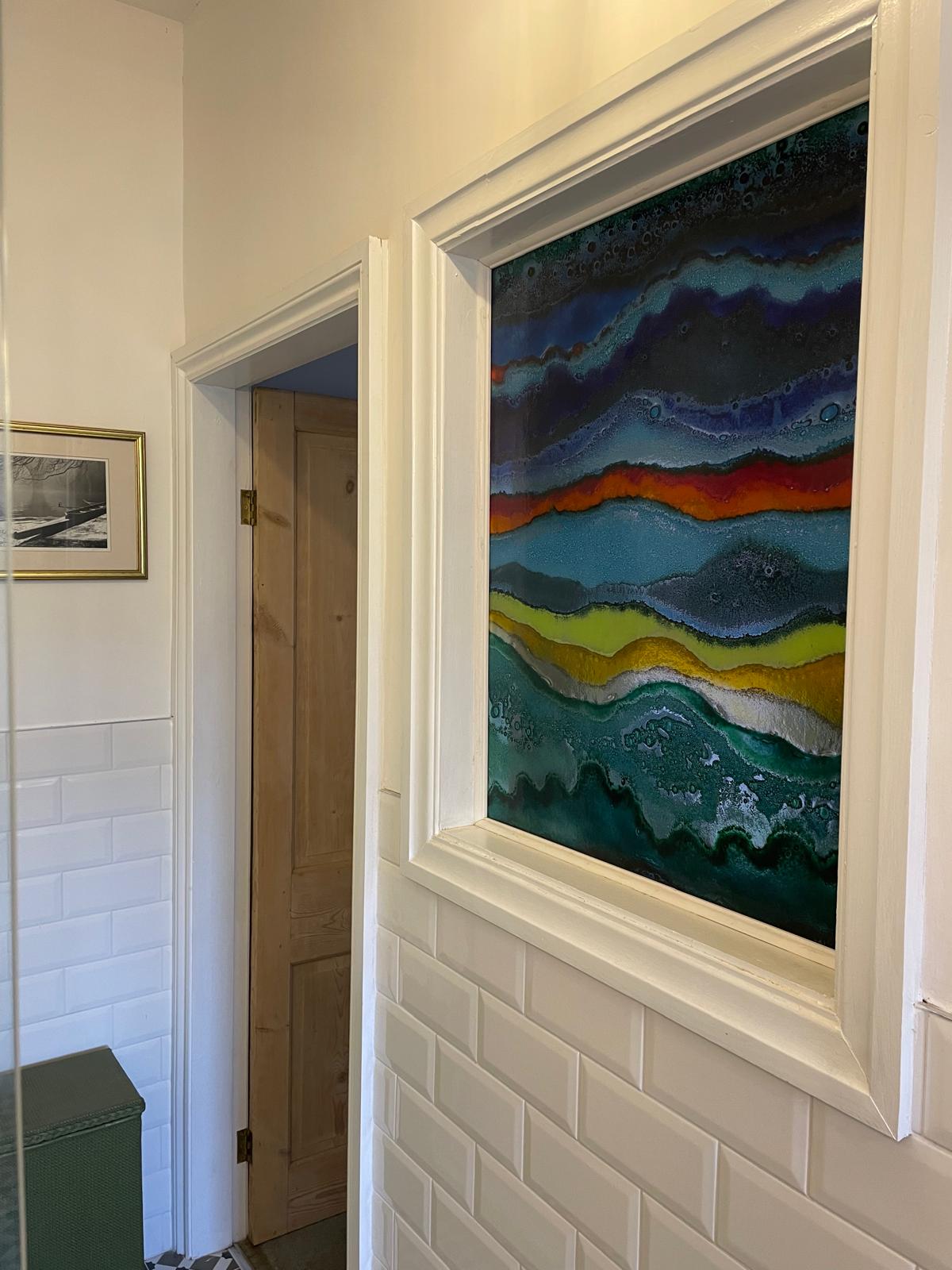 Luxury cottage bathroom featuring stylish wall art, white tiled walls, and a modern door design