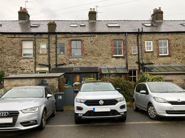 Stone cottage exterior with parking, featuring traditional architecture and a charming garden entrance