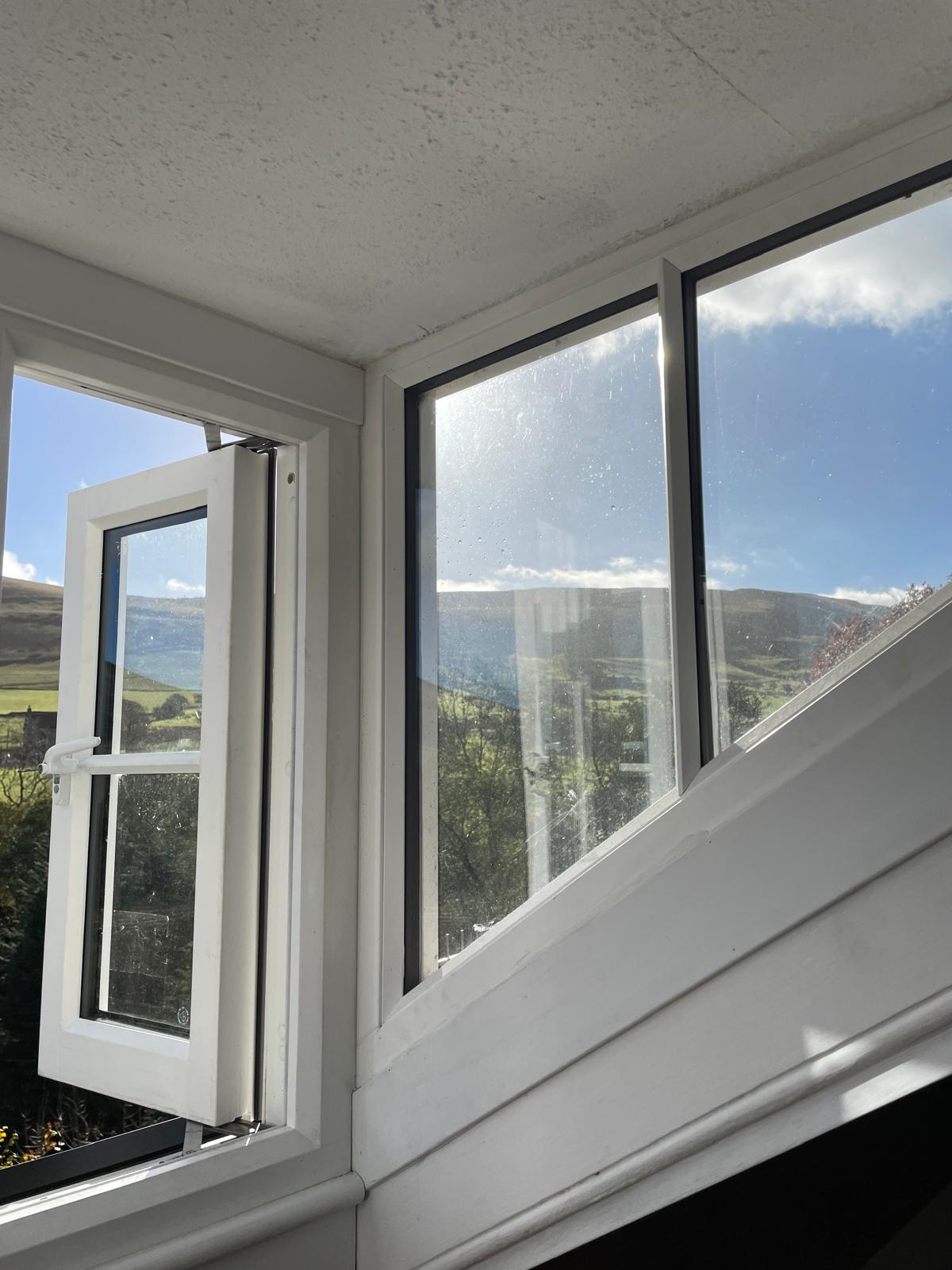 Bright window view showcasing lush greenery and rolling hills, enhancing the airy feel of this luxury cottage