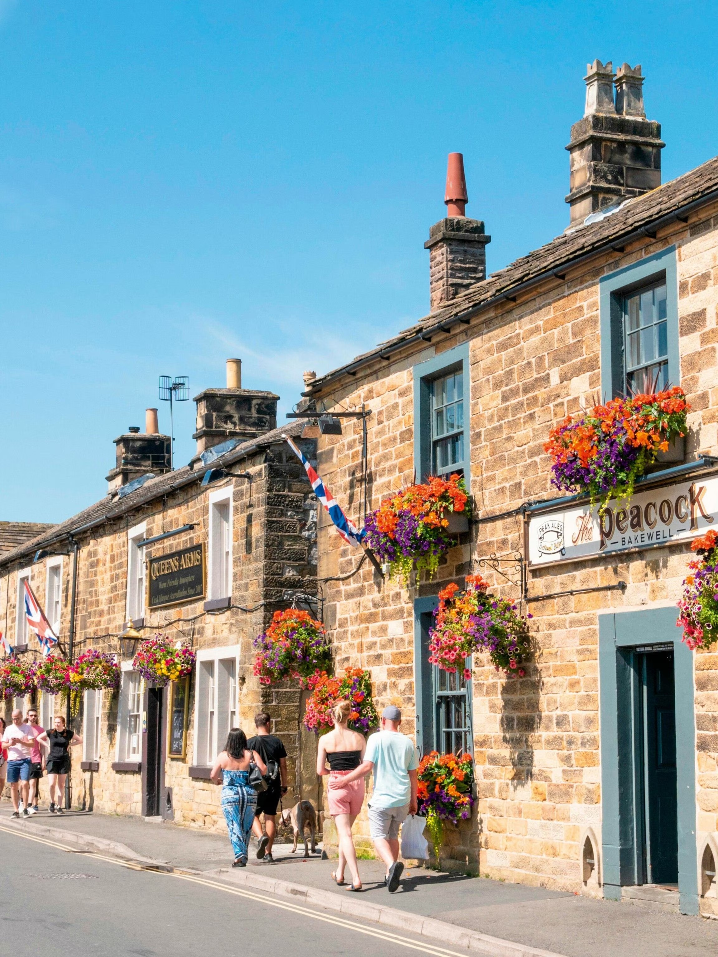 Charming stone cottage exterior with vibrant flower displays, inviting atmosphere, and traditional architecture