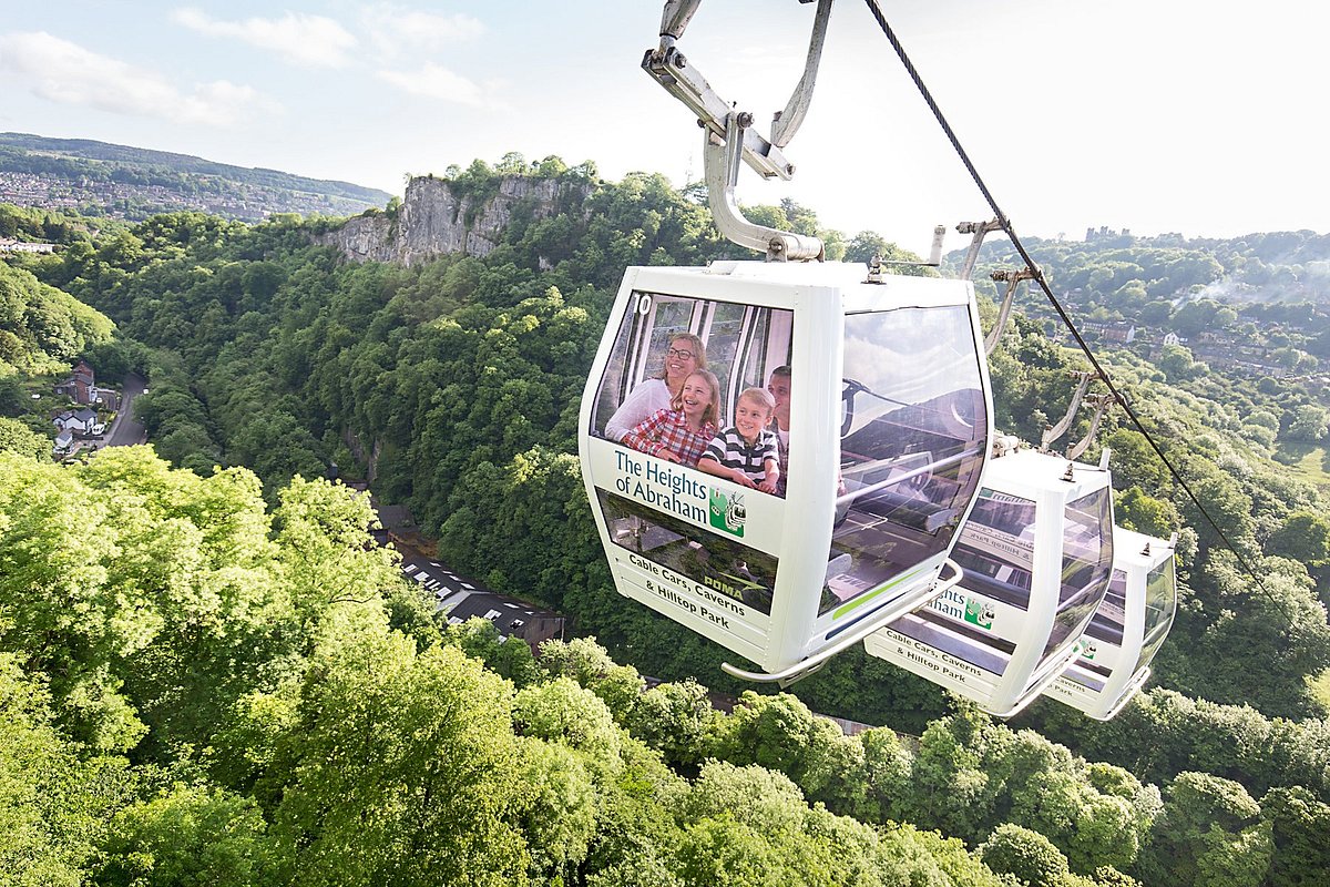 A scenic view of a cable car ride over lush greenery, showcasing family enjoyment and stunning mountain landscapes
